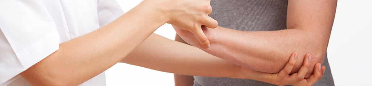 Female physiotherapist examining and massaging a hand